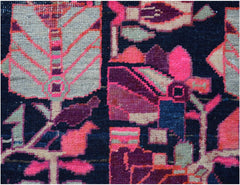 A close-up of a vintage Persian rug featuring geometric floral patterns in pink, purple, and grey.