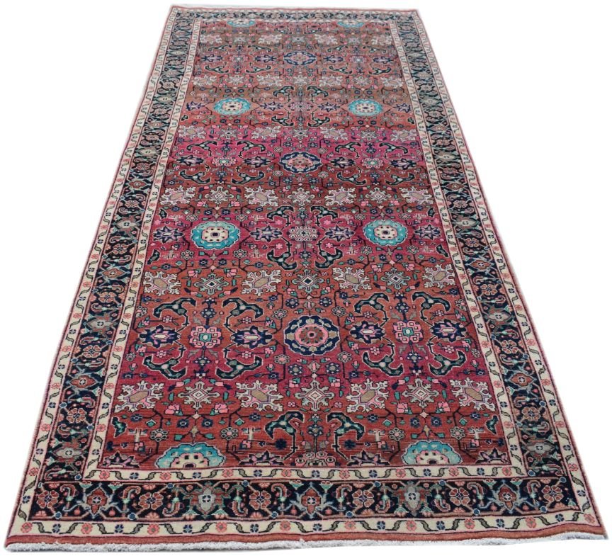 A handmade vintage Persian runner rug featuring a vibrant red field with intricate floral patterns.