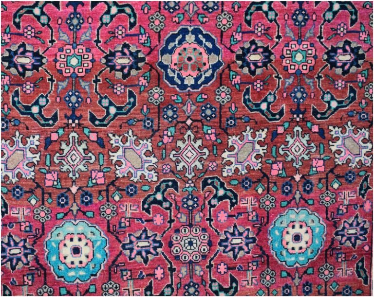 A handmade vintage Persian wool rug featuring a vibrant floral and geometric tribal pattern.