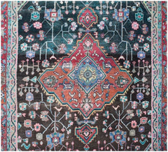 A vintage handmade Persian wool rug featuring a central geometric medallion on a dark field.