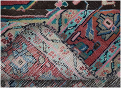 A close-up view of a handmade vintage Persian rug showing its intricate floral pattern and weave.