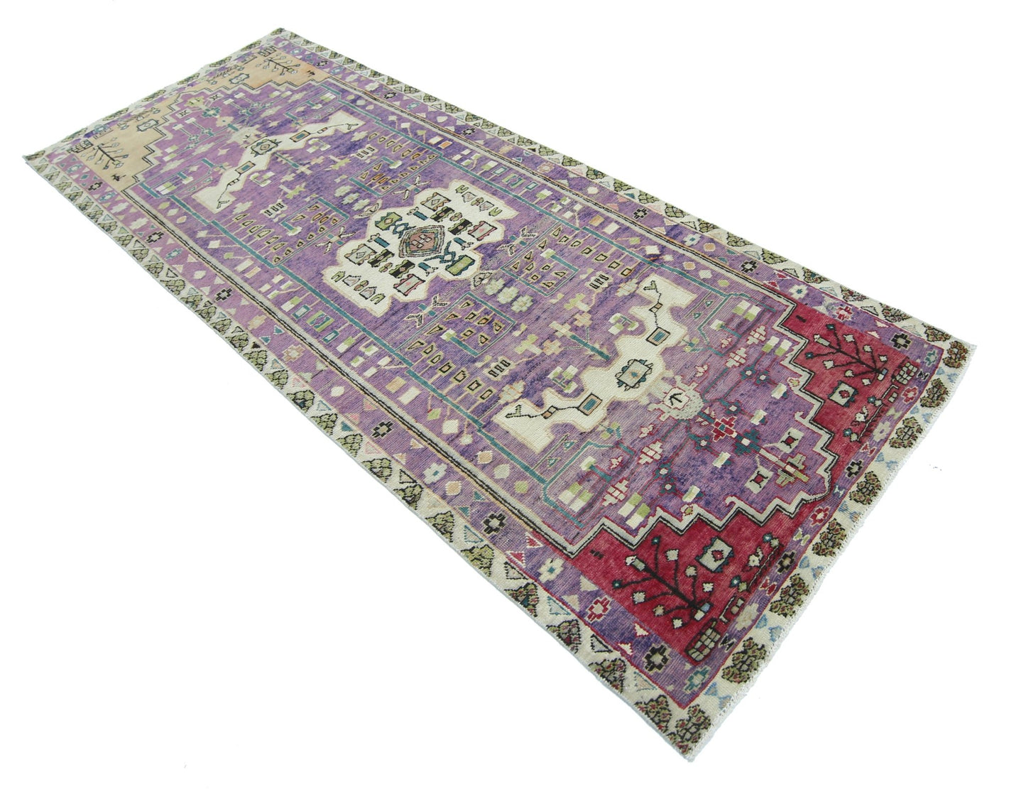 A rectangular vintage Persian rug featuring a purple field with intricate geometric patterns.