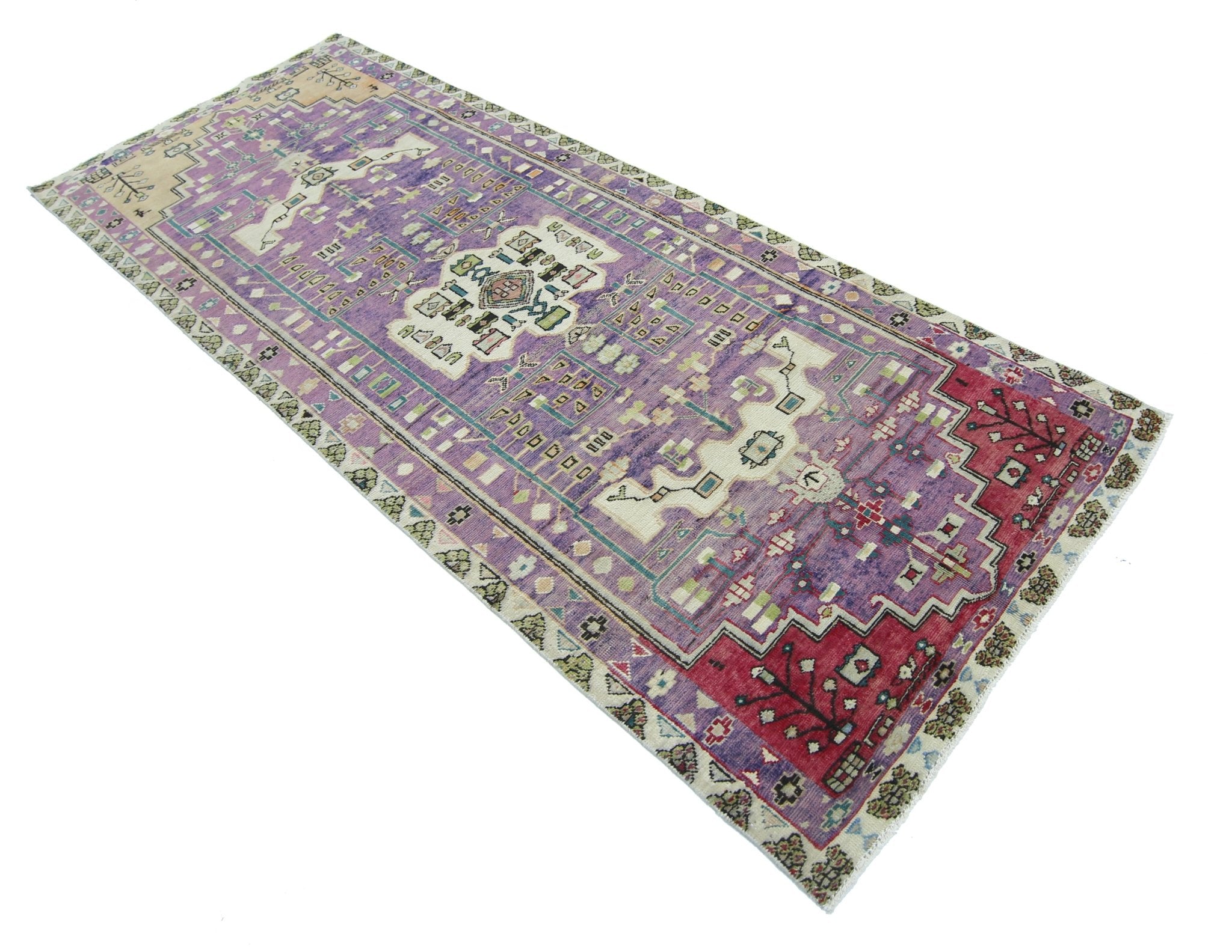 A rectangular vintage Persian rug featuring a purple field with intricate geometric patterns.