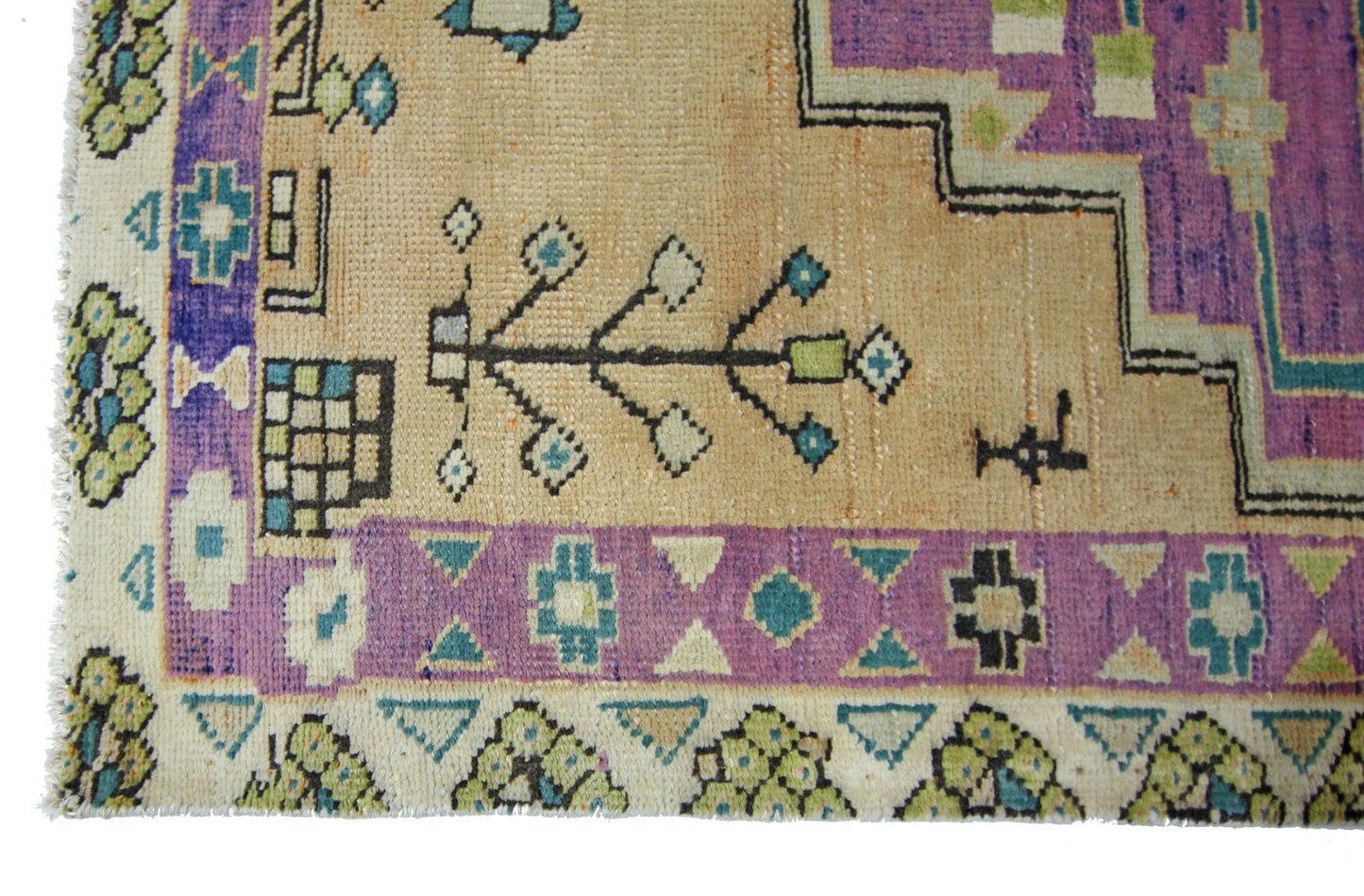 A vintage Persian rug featuring geometric patterns in purple, beige, green, and blue.