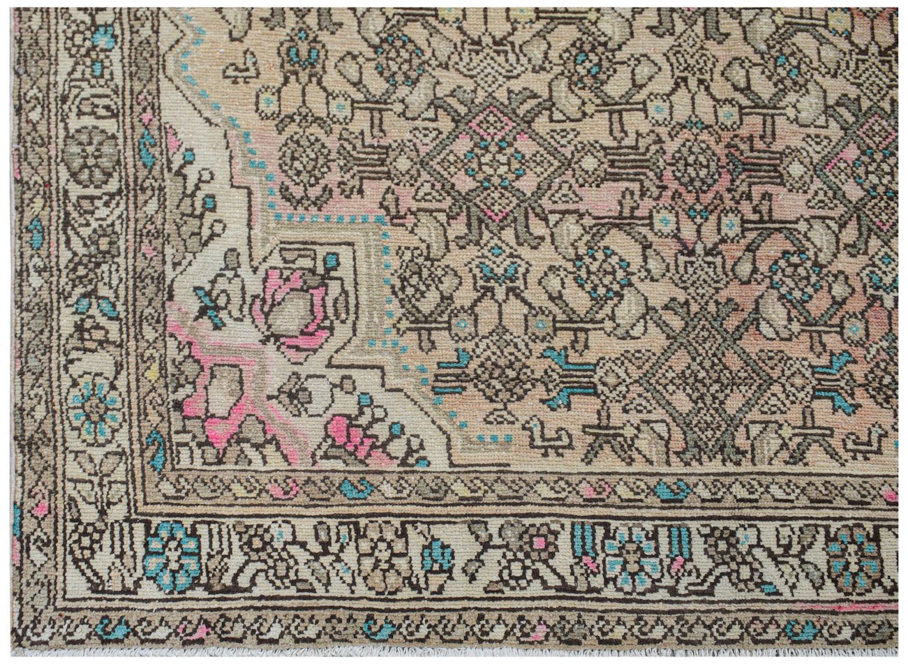 A handwoven vintage Persian rug featuring intricate floral patterns in muted pink and blue tones.