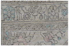 Vintage Persian rug with a woven pattern in neutral tones and subtle blue and pink accents.