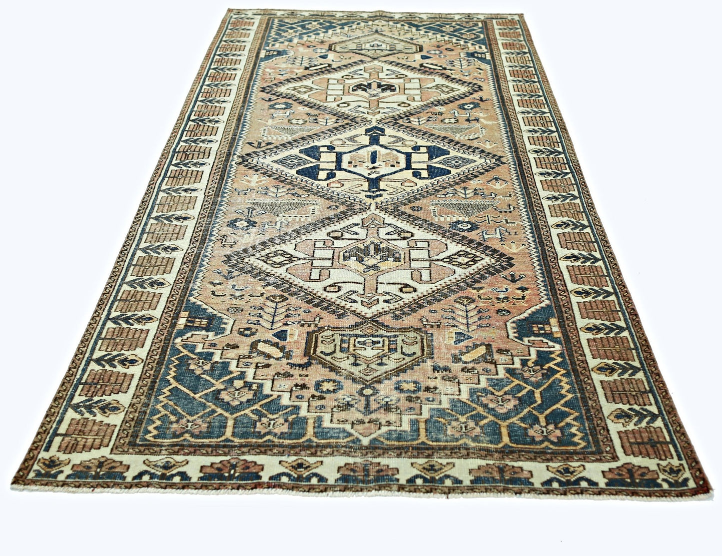 A vintage Persian rug featuring a geometric diamond pattern in shades of blue and tan.