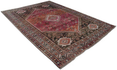 A handmade vintage Persian wool rug featuring a central medallion and intricate tribal patterns.