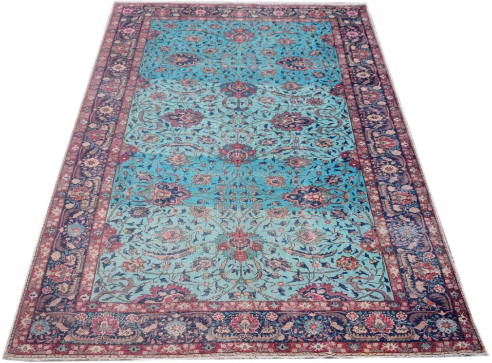 A vintage handmade Persian rug featuring a floral pattern in shades of blue, red, and cream.