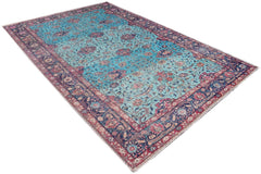 A vintage handmade Persian rug featuring a vibrant turquoise field with intricate floral patterns.