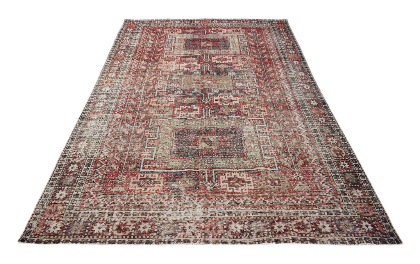 A rectangular vintage Persian rug featuring a distressed red and beige geometric pattern.