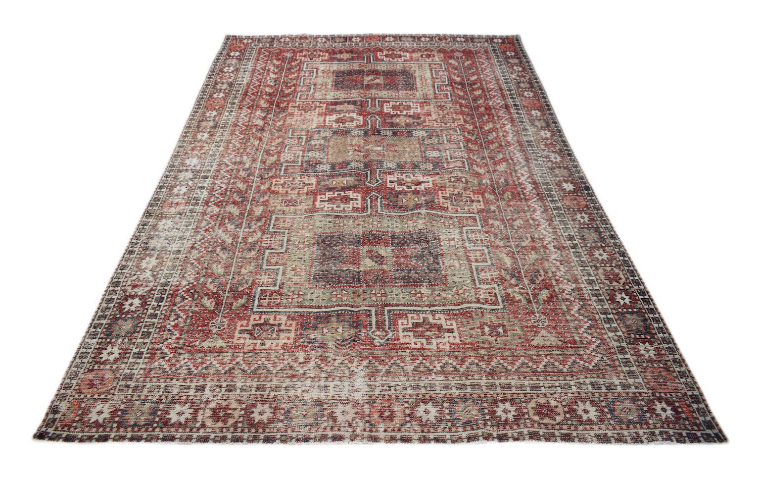 A rectangular vintage Persian rug featuring a distressed red and beige geometric pattern.