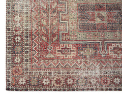 Vintage Persian rug with red, blue, and green geometric patterns.