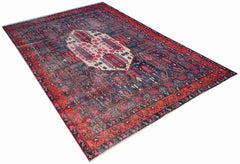 A vintage handwoven Persian rug featuring a central cream medallion on a dark blue and red field.