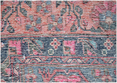 A close-up of a vintage Persian rug featuring intricate floral patterns in red, blue, and cream.