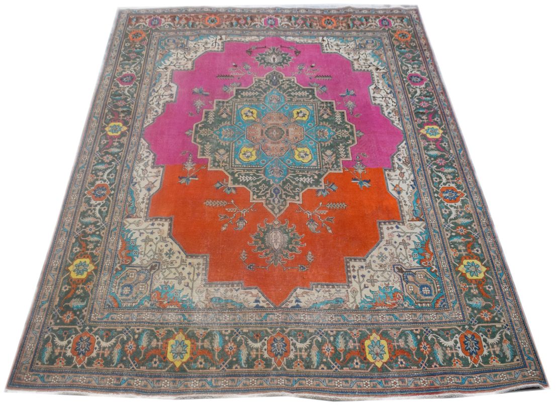 A handmade vintage Persian rug featuring a split pink and orange field with a central medallion.