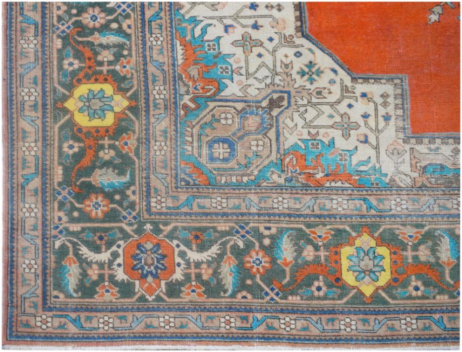A vintage Persian rug featuring a dark green border with floral motifs and a vibrant orange center.