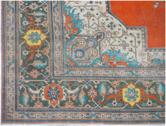 A vintage Persian rug featuring a dark green border with floral motifs and a vibrant orange center.