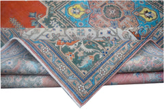 A folded vintage Persian wool rug featuring intricate tribal patterns in blue, orange, and green.