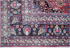 A vintage handmade Persian rug featuring a dark field with intricate floral and paisley patterns.