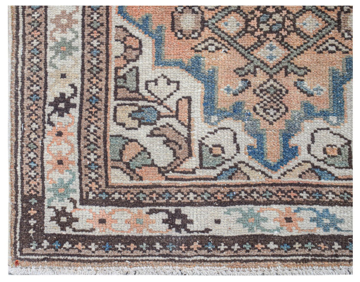 A handwoven vintage Persian runner featuring a geometric pattern in muted orange, blue, and cream.