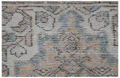 A handwoven vintage Persian runner featuring a faded geometric pattern in blue and tan tones.