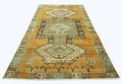 A vintage Persian runner rug featuring geometric patterns in shades of orange, brown, and grey.