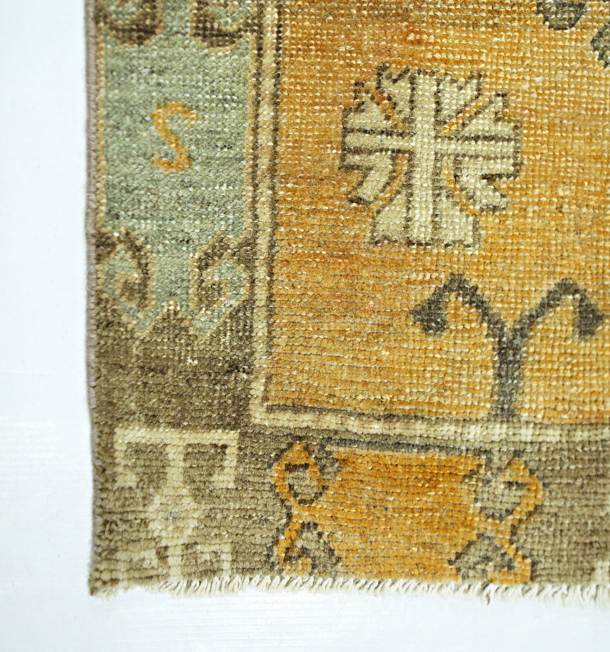 A vintage Persian runner featuring a geometric pattern in shades of gold, green, and brown.