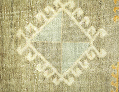 A close-up of a vintage Persian runner featuring a central diamond motif with geometric patterns.
