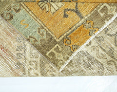 A close-up view of a vintage Persian runner showing its wool pile, cotton base, and worn texture.