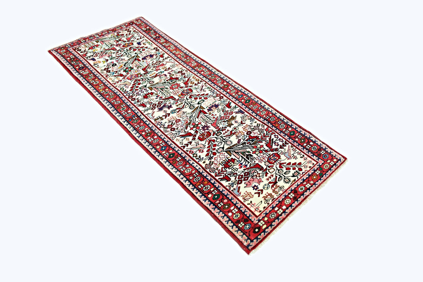 A vintage handmade Persian runner rug featuring a detailed floral pattern in red, white, and blue.