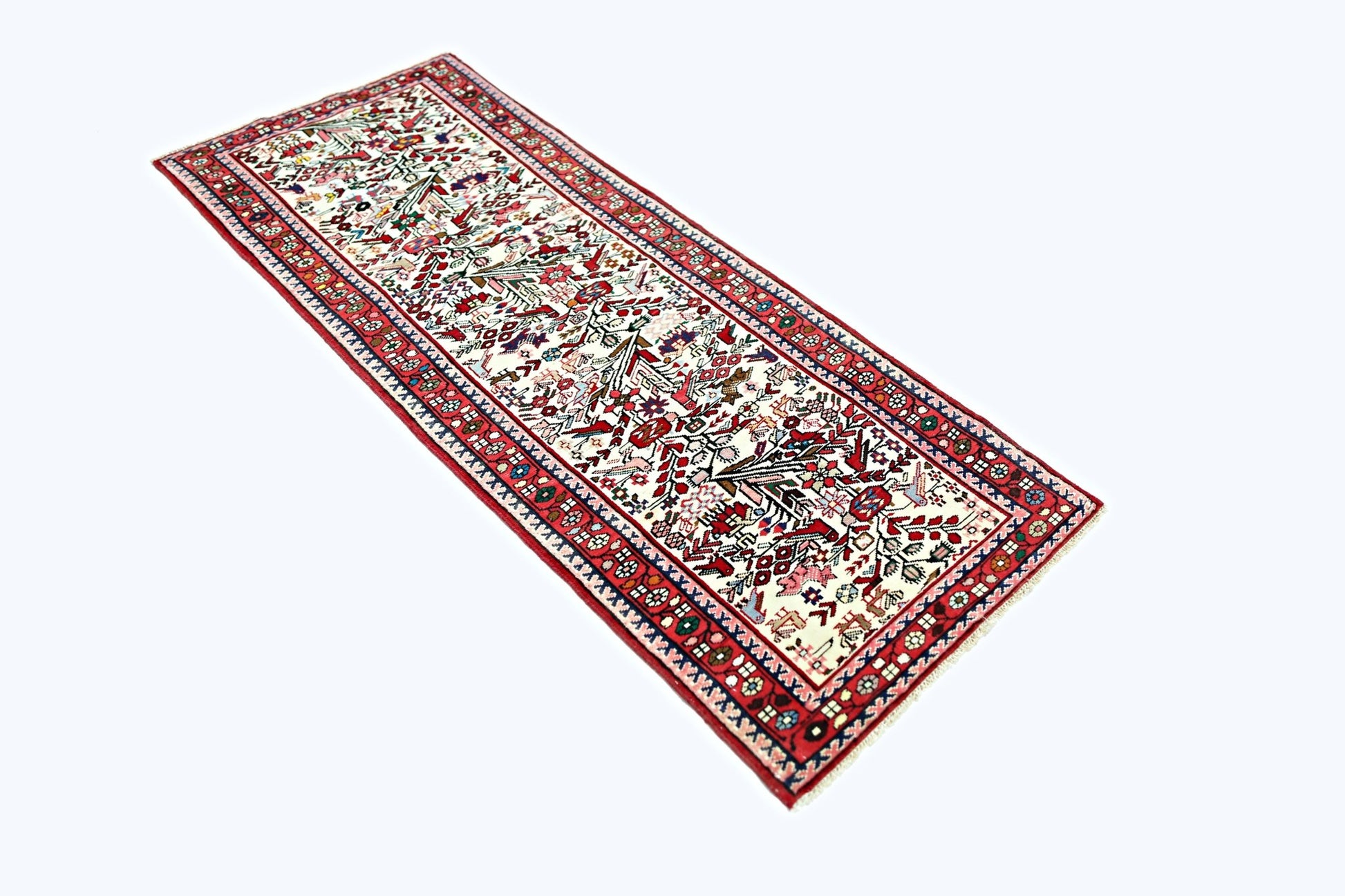 A vintage handmade Persian runner rug featuring a detailed floral pattern in red, white, and blue.