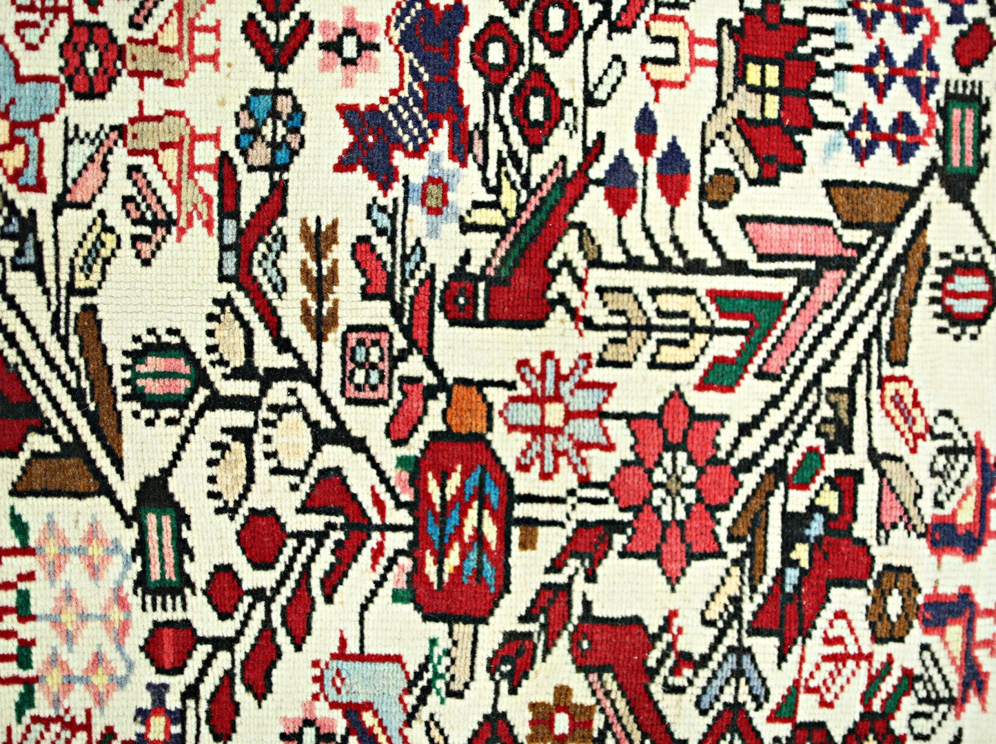 A vintage Persian runner featuring intricate floral and bird motifs in vibrant colors.