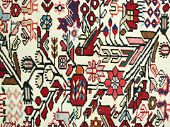 A vintage Persian runner featuring intricate floral and bird motifs in vibrant colors.