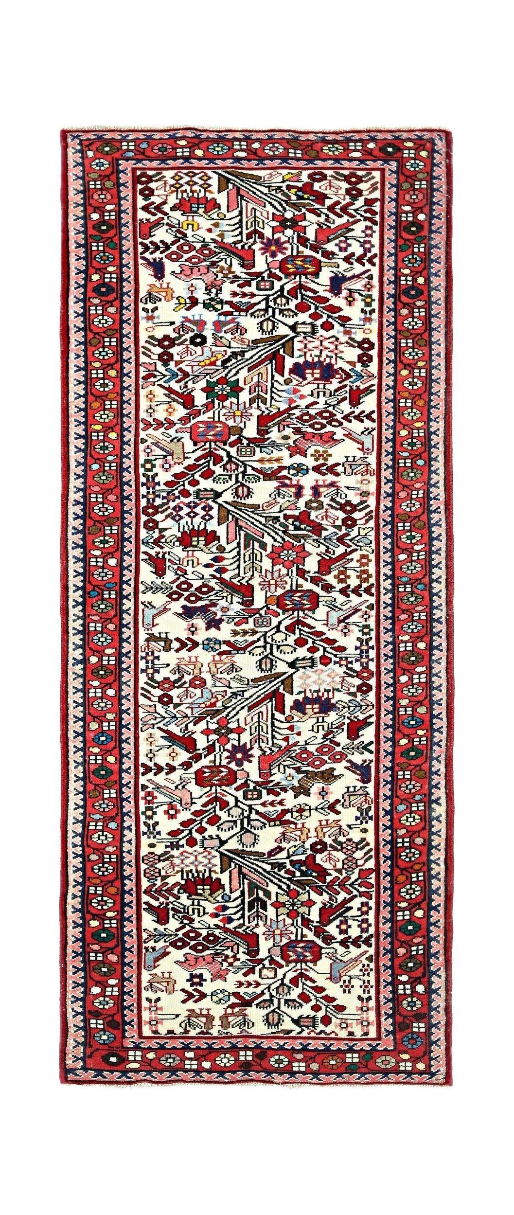 A vintage handmade Persian runner featuring a cream field with colorful floral and bird motifs.