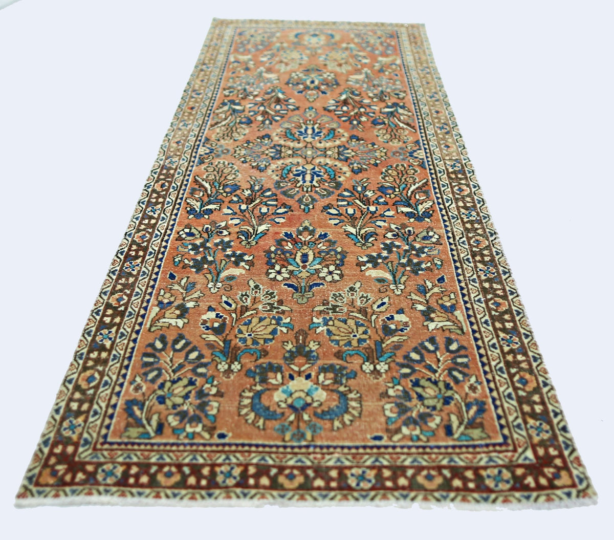 A vintage Persian runner rug featuring intricate floral patterns in shades of orange and blue.