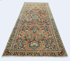 A vintage Persian runner rug featuring intricate floral patterns in shades of orange and blue.