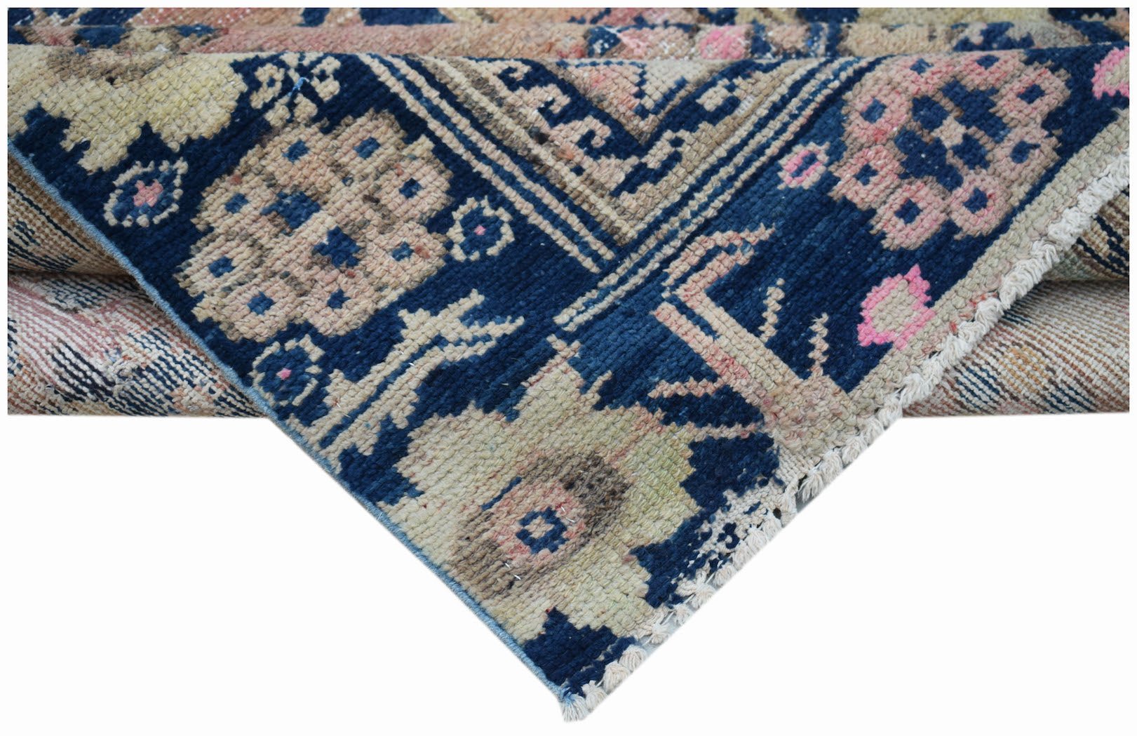 A vintage handwoven Persian runner featuring a geometric floral pattern in blue, pink, and beige.