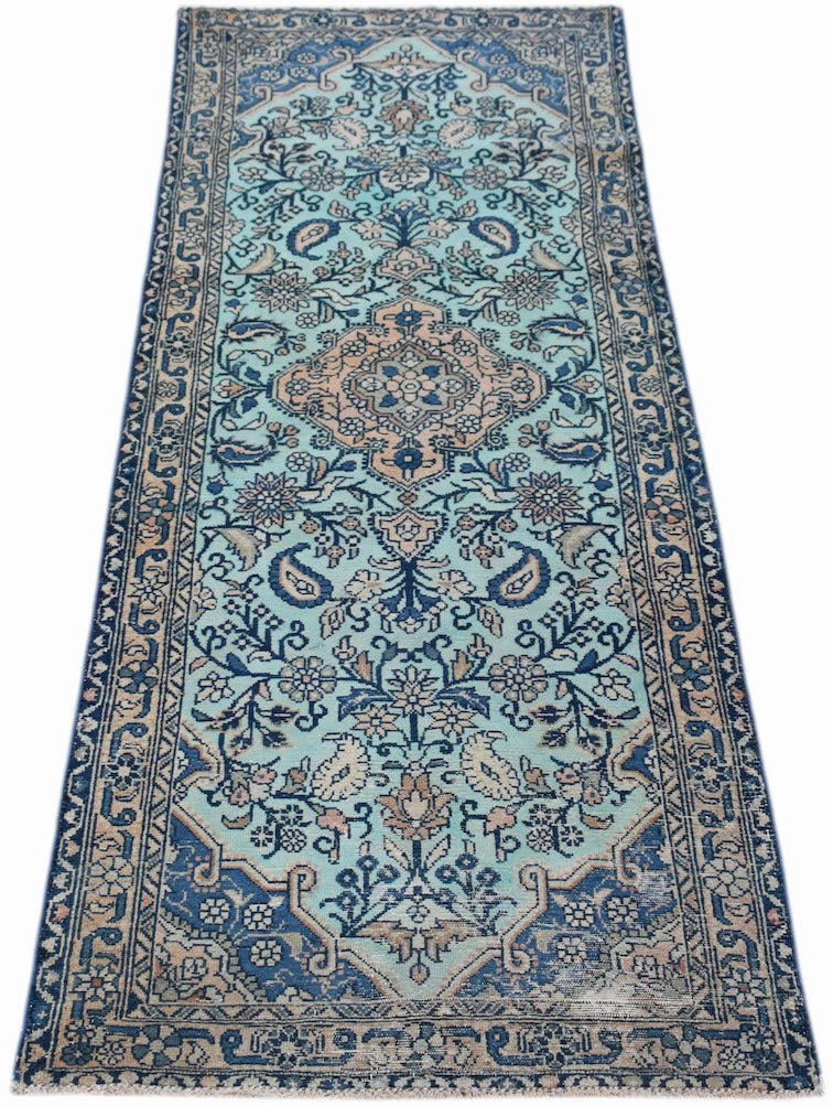 A vintage handwoven Persian runner featuring a floral pattern in shades of blue and beige.