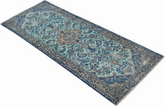 A vintage handwoven Persian runner featuring a floral pattern in shades of blue and beige.