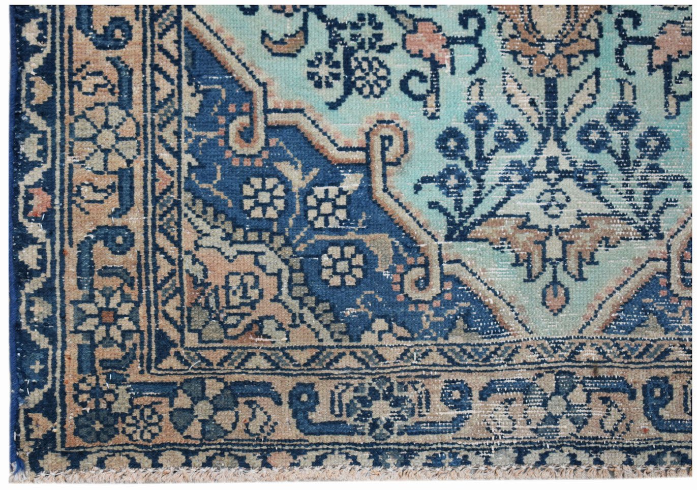 A vintage Persian runner featuring a geometric floral pattern in shades of blue and tan.