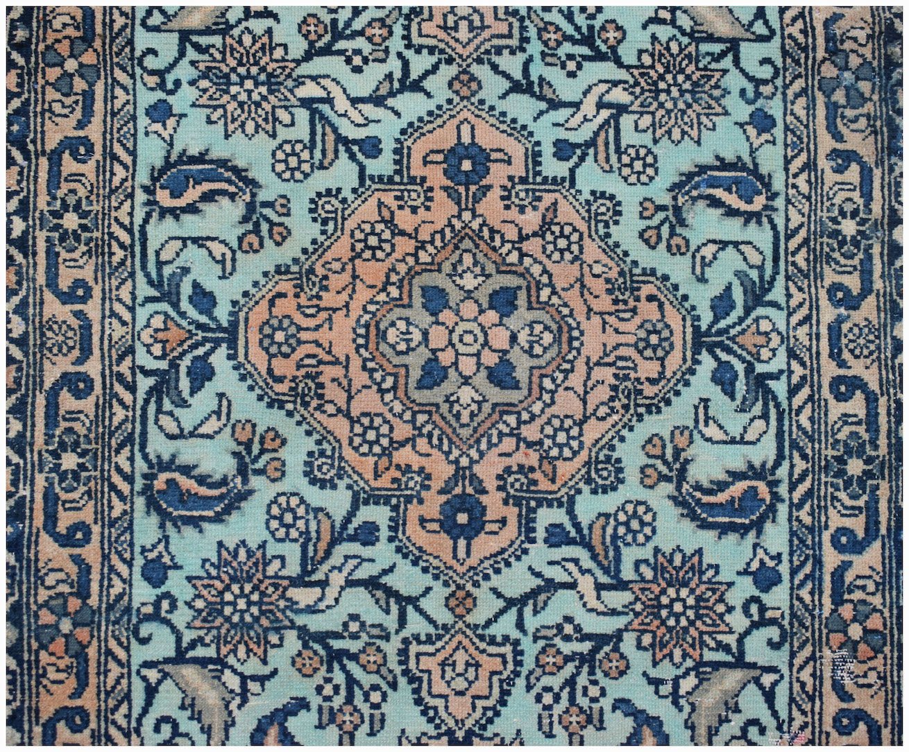A vintage Persian runner featuring a central floral medallion on a light blue wool field.