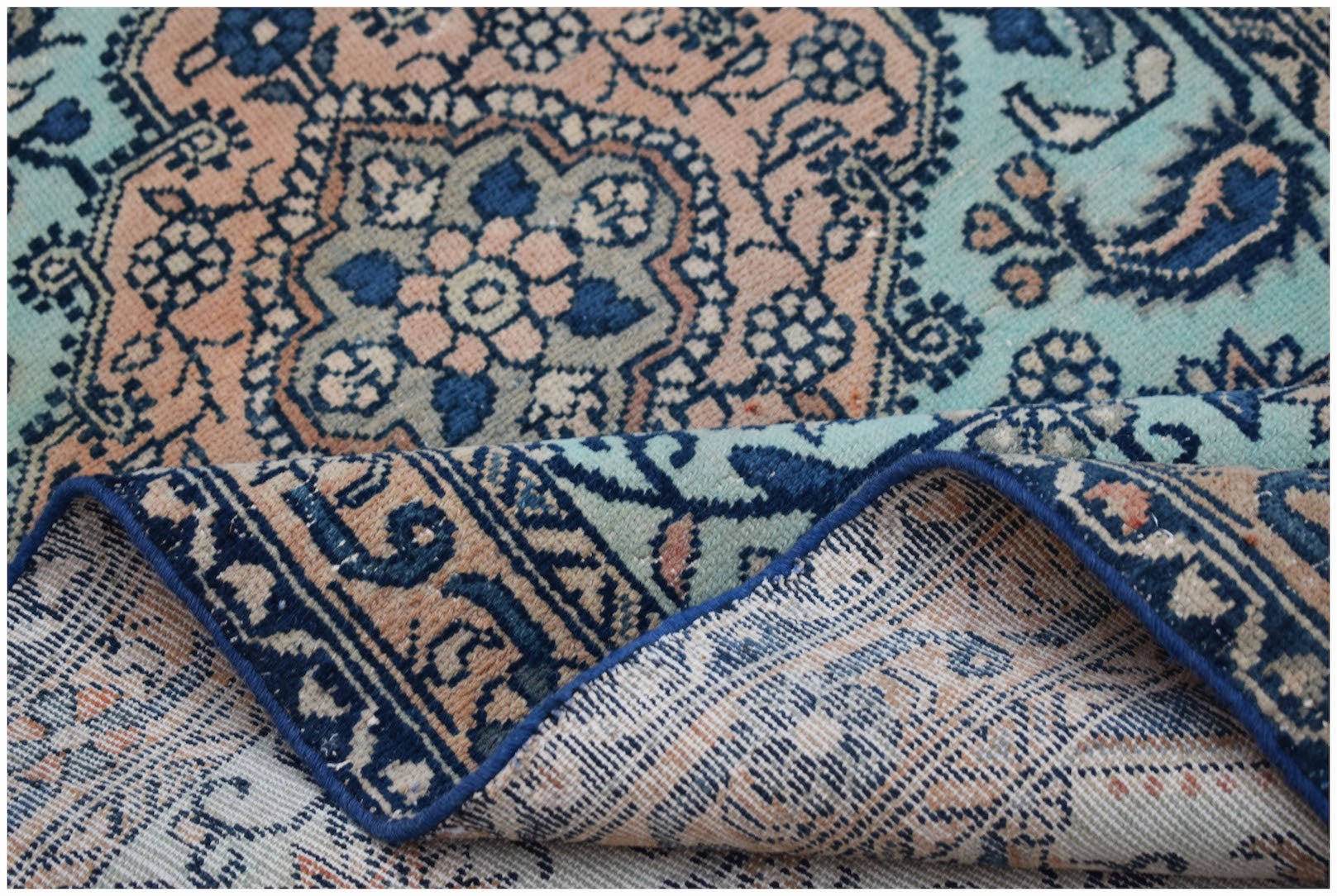 A vintage Persian runner with a floral medallion pattern in shades of blue and peach.