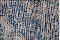 A close-up of a vintage Persian runner featuring intricate floral patterns in blue and tan tones.