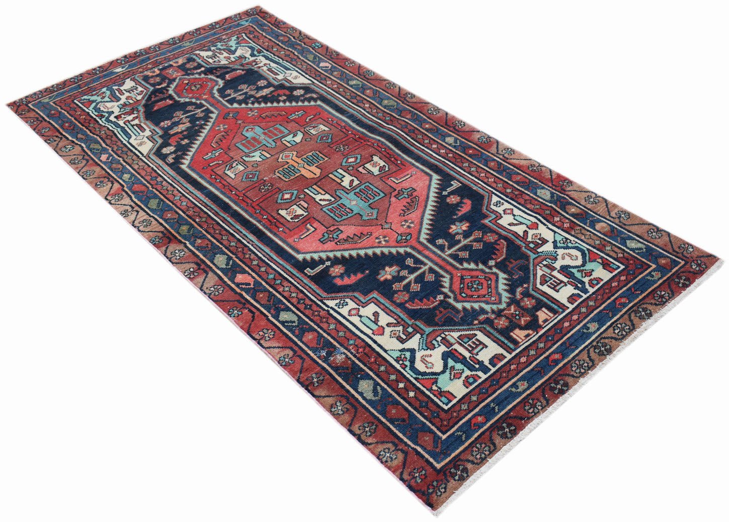 A handwoven vintage Persian runner featuring a geometric medallion pattern in red and navy blue.