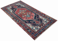 A handwoven vintage Persian runner featuring a geometric medallion pattern in red and navy blue.