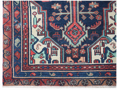 A handwoven vintage Persian runner featuring a geometric medallion pattern in blue, red, and cream.