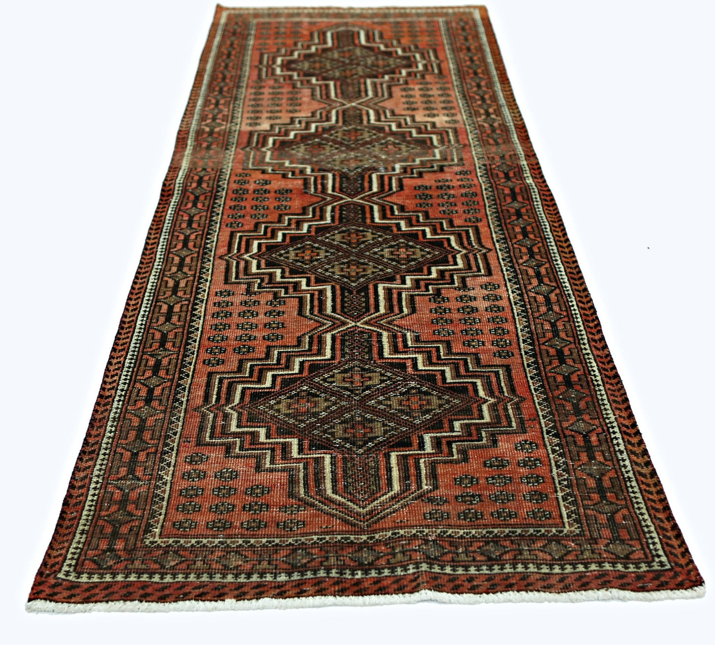 A vintage Persian runner featuring a geometric pattern in shades of red, black, and brown.