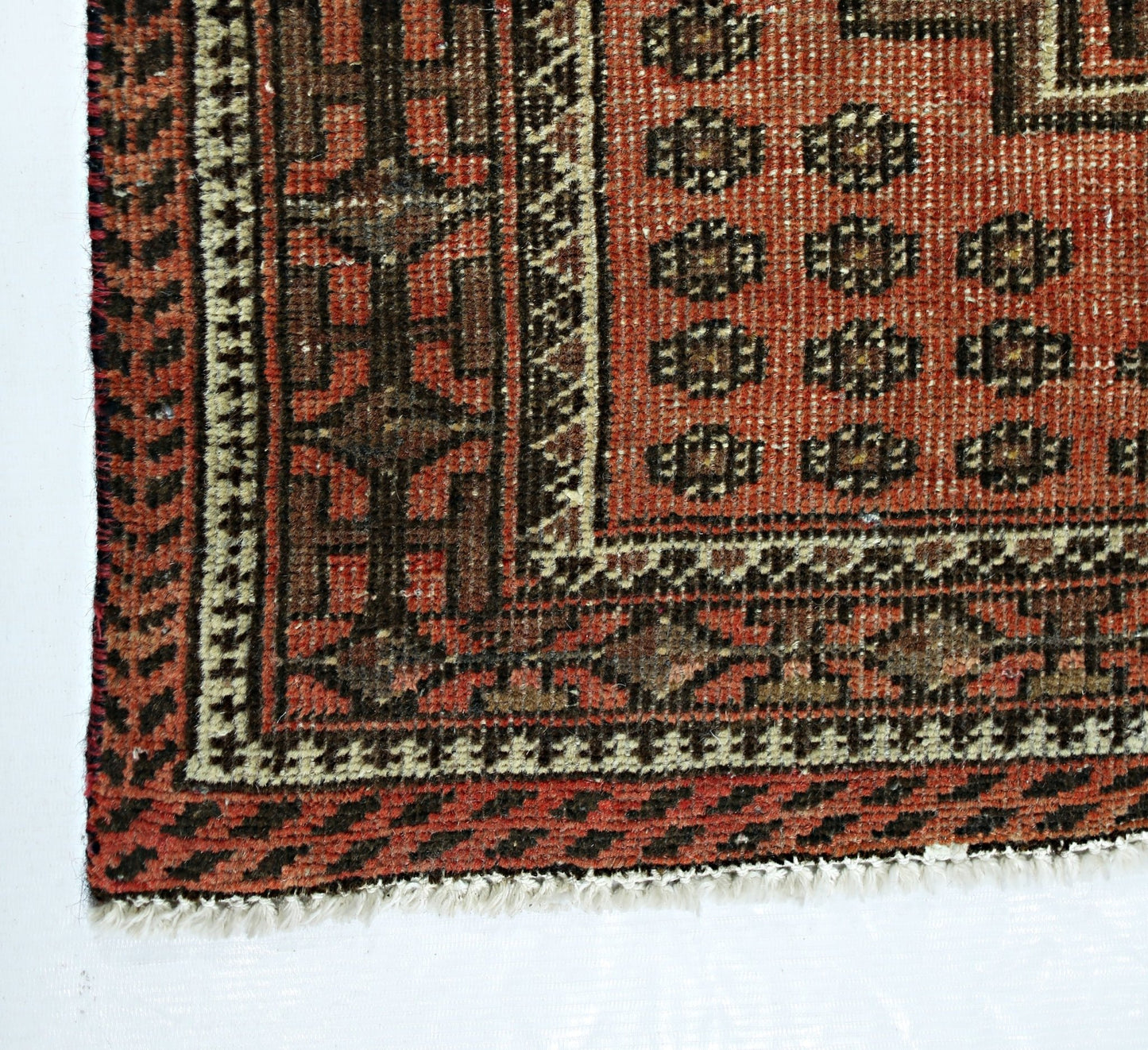 A vintage Persian runner featuring a geometric pattern in shades of red, brown, and cream.