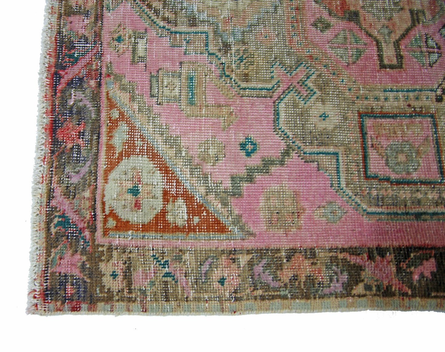 A vintage Persian runner featuring a pink field with geometric patterns and a decorative border.